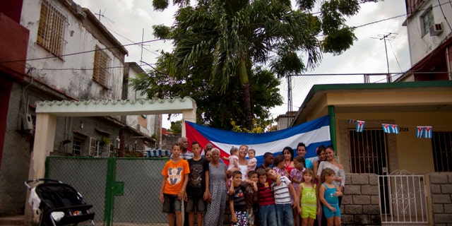 Pairs of twins pose for a group portrait near a Siguaraya tree along their street in Havana, Cuba.