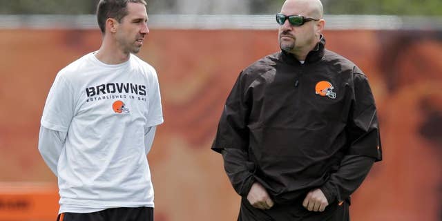 Cleveland Browns offensive coordinator Kyle Shanahan, left, talks with head coach Mike Pettine during a voluntary minicamp workout at the NFL football team's facility in Berea, Ohio Thursday, May 1, 2014. (AP Photo/Mark Duncan)