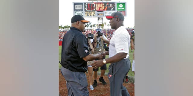 Cincinnati Bengals head coach Marvin Lewis, left, shakes hands with Tampa Bay Buccaneers head coach Lovie Smith after the Bengals defeated the Buccaneers 14-13 during an NFL football game Sunday, Nov. 30, 2014, in Tampa, Fla. (AP Photo/Brian Blanco)