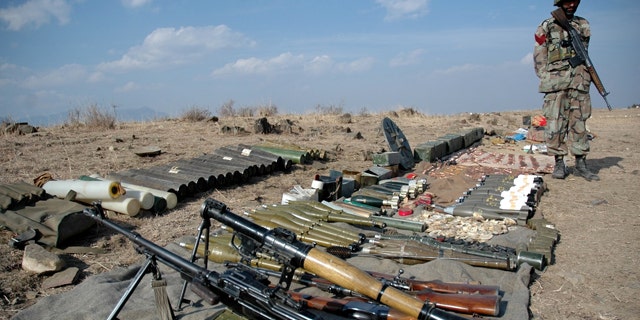 Pakistan army soldier stands next to ammunition seized from militants in Wana of Pakistani tribal region of Waziristan.
