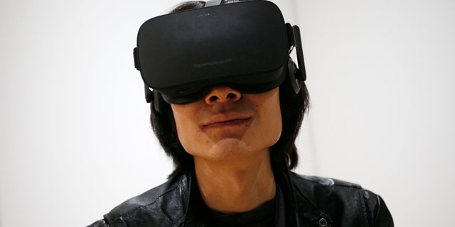 File photo - Peijun Guo wears the Oculus Rift VR headset at the Oculus booth at CES International, Wednesday, Jan. 6, 2016, in Las Vegas. (AP Photo/John Locher)