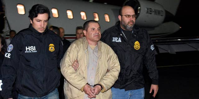 In this photo provided U.S. law enforcement, authorities escort Joaquin "El Chapo" Guzman, center, from a plane to a waiting caravan of SUVs at Long Island MacArthur Airport on Thursday, Jan. 19, 2017, in Ronkonkoma, N.Y.