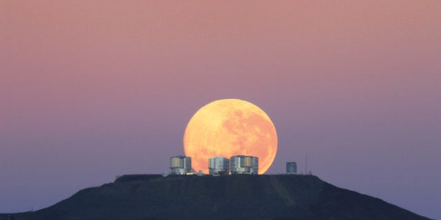The dazzling full moon sets behind the Very Large Telescope in Chile's Atacama Desert in this photo released June 7, 2010 by the European Southern Observatory. The moon appears larger than normal due to an optical illusion of perspective.