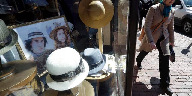 FILE - In this April 1, 2015 file photo, a pedestrian passes the entrance of a hat store in the Harvard Square neighborhood of Cambridge, Mass. The Commerce Department releases its March report on consumer spending, which accounts for 70 percent of economic activity, on Thursday, April 30, 2015. (AP Photo/Steven Senne, File)