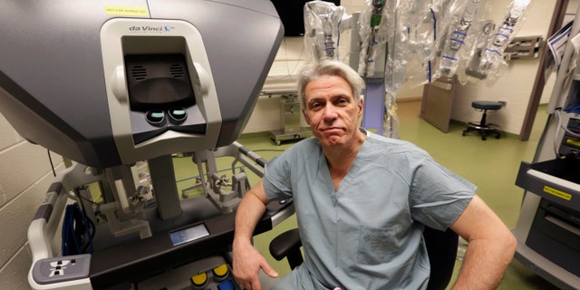Dr. Pier Giulianotti, chief of minimally invasive and robotic surgery at the University of Illinois Hospital &amp; Health Sciences System in Chicago, sits at the control panel of the da Vinci robot system.