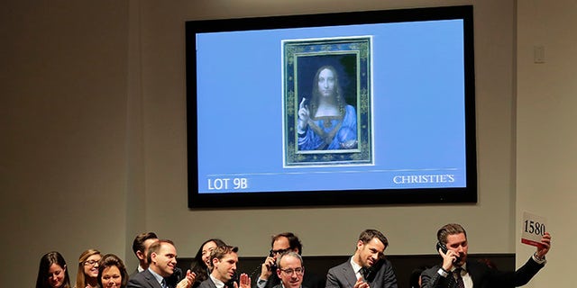Bidding representatives react after Leonardo da Vinci's "Salvator Mundi" sold for $450 million at Christie's, Wednesday, Nov. 15, 2017, in New York. (AP Photo/Julie Jacobson)