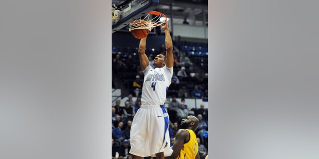 Air Force forward Kamryn Williams (4) dunks over Wyoming forward Leonard Washington during the first half of their NCAA college basketball game, Tuesday, Feb. 26, 2013, at Air Force Academy, Colo. (AP Photo/The Colorado Springs Gazette, Christian Murdock) MAGS OUT