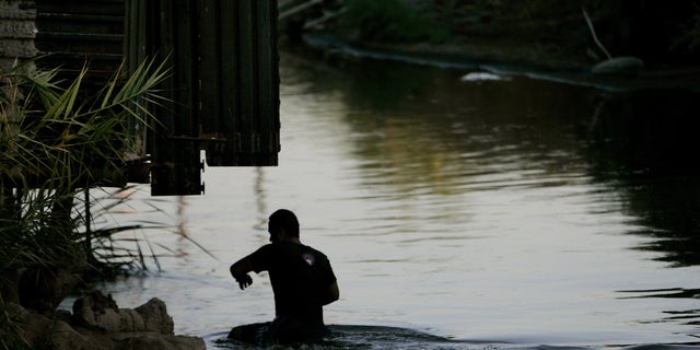 CALEXICO, CA - OCTOBER 9:  A migrant crosses the New River in Calexico, California October 9, 2007.  Immigration continues to be a hot topic among political contenders and economic watchdogs.  (Photo by Sandy Huffaker/Getty Images)