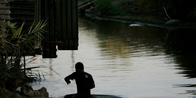 CALEXICO, CA - OCTOBER 9: A migrant crosses the New River in Calexico, California October 9, 2007. Immigration continues to be a hot topic among political contenders and economic watchdogs. (Photo by Sandy Huffaker/Getty Images)