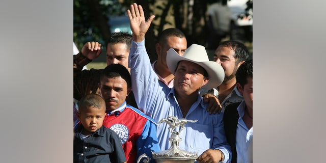 FILE - In this Sept. 6, 2010 file photo, owner Jose Trevino Morales, center, acknowledges the crowd as he stood with the trophy after Mr. Piloto won the All American Futurity horse race at Ruidoso Downs, N.M. Prosecutors told a federal jury on Wednesday, May 8, 2013 that Morales, the man they say is the brother of leaders of Mexico's most blood-soaked criminal organization, used the proceeds from their brothers' ill-gotten gains to bankroll his horse-racing stable. (AP Photo/The El Paso Times, Rudy Gutierrez) EL DIARIO OUT; JUAREZ MEXICO OUT;