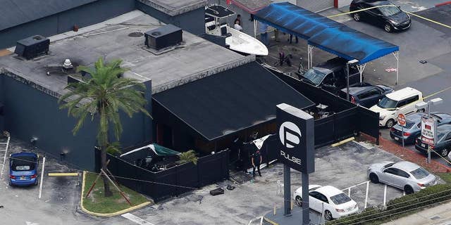 FILE - In this June 12, 2016 file photo, law enforcement officials work at the Pulse nightclub in Orlando, Fla., following a mass shooting. As many as 1,000 potential jurors in the trial of the Orlando nightclub gunman’s wife will have to answer an extensive questionnaire about how much they know about the case. That highlights how complicated it could be to find unbiased jurors in the prosecution of the only case related to the worst mass shooting in modern U.S. history. (AP Photo/Chris O'Meara, File)