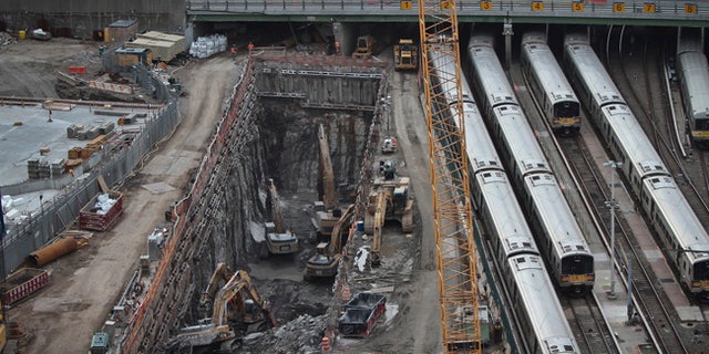 FILE - In this April 17, 2014, file photo, backhoes excavate in a hole reserved for a rail tunnel, left, during the early days of construction at the Hudson Yards redevelopment site on Manhattan's west side in New York. A concrete box was planned inside the project to preserve space for a tunnel from Newark to New York City that would allow it to double rail capacity across the Hudson River. An environmental study has been released for the Hudson River rail tunnel project, amid concerns the effort could lose key federal funding under President Donald Trump's proposed budget. (AP Photo/Bebeto Matthews, File)