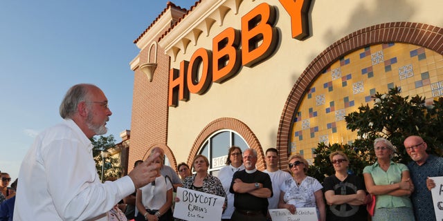 Rev. Bruce Prescott, left, speaks during a vigil outside a Hobby Lobby store in Edmond, Okla., Monday, June 30, 2014.