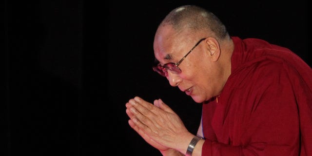 Jan. 13, 2015: Tibetan spiritual leader the Dalai Lama greets the audience as he arrives to speak on "A Human Approach to World Peace" at Presidency College in Kolkata, India.
