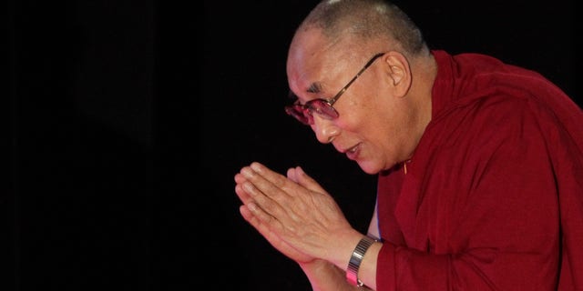 Jan. 13, 2015: Tibetan spiritual leader the Dalai Lama greets the audience as he arrives to speak on "A Human Approach to World Peace" at Presidency College in Kolkata, India.