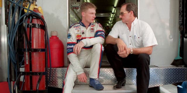 Dale Earnhardt Jr. and Dale Earnhardt Sr., sit on the back of a transporter discussing Earnhardt Jr.'s preparation for Carquest 300 Grand National qualifications on May 21, 1998 in Concord, North Carolina. (Photo by Jeff Siner/Charlotte Observer/MCT via Getty Images)
