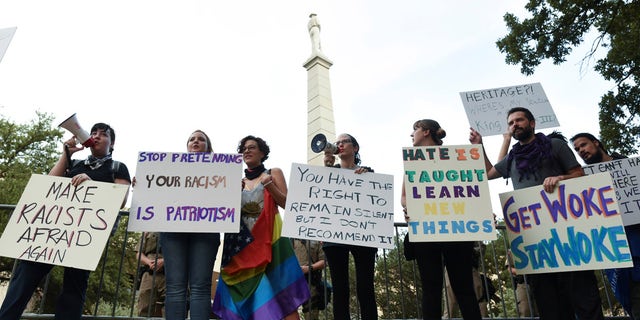 Protesters are seen in front of a Confederate monument in Dallas before a "Dallas Against White Supremacy" rally on August 19, 2017.