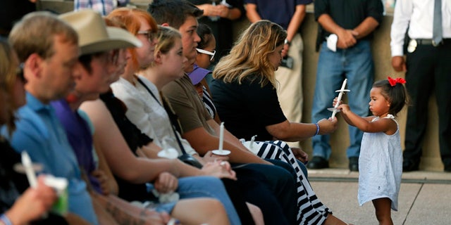 Family and friends of fallen police officers take part in a candlelight vigil at City Hall on Monday, July 11, 2016, in Dallas. Five police officers were killed and several injured during a shooting in downtown Dallas last Thursday night. (AP Photo/Tony Gutierrez)