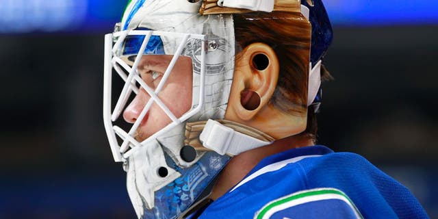 VANCOUVER, BC - NOVEMBER 13: Jacob Markstrom #25 of the Vancouver Canucks dons a new mask during warmup before their NHL game against the Dallas Stars at Rogers Arena November 13, 2016 in Vancouver, British Columbia, Canada. (Photo by Jeff Vinnick/NHLI via Getty Images)