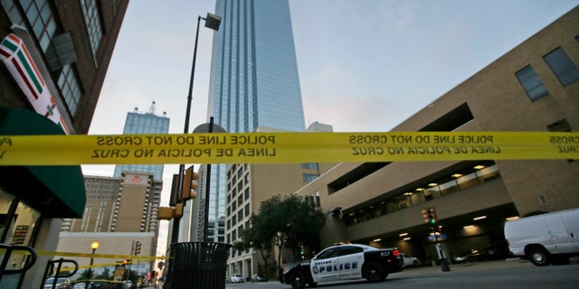 Police tape marks off the area where a shooting took place in downtown Dallas, Friday, July 8, 2016. Snipers opened fire on police officers in the heart of Dallas during protests over two recent fatal police shootings of black men. (AP Photo/LM Otero)