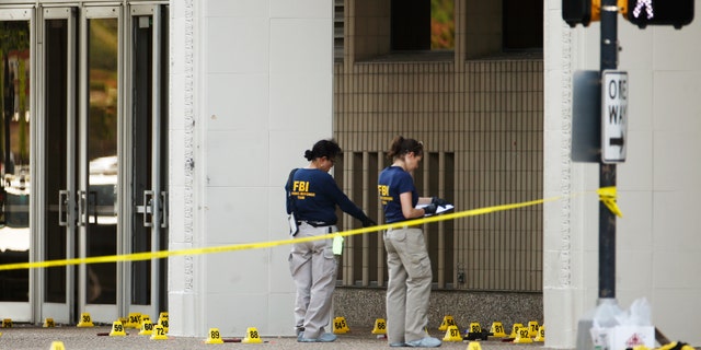 FBI investigators look over the crime scene in Dallas, Texas, U.S. July 8, 2016 following a Thursday night shooting incident that killed five police officers. (REUTERS/Carlo Allegri)