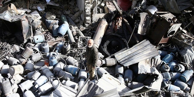 A man stands on the rubble of damaged buildings after an airstrike on the rebel-held town of Mesraba in the eastern Damascus suburb of Ghouta, Syria, November 26, 2017.