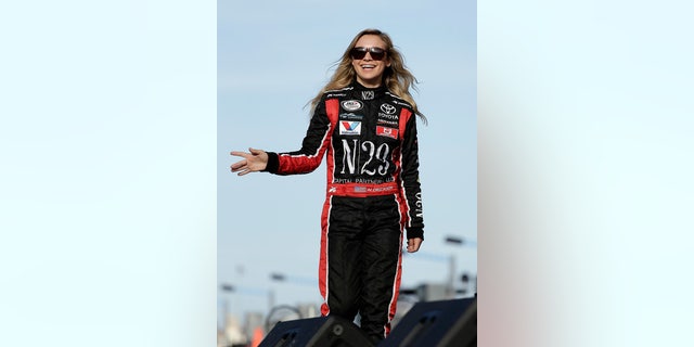 Natalie Decker waves to fans during driver introductions before starting her ARCA race at Daytona on pole position.