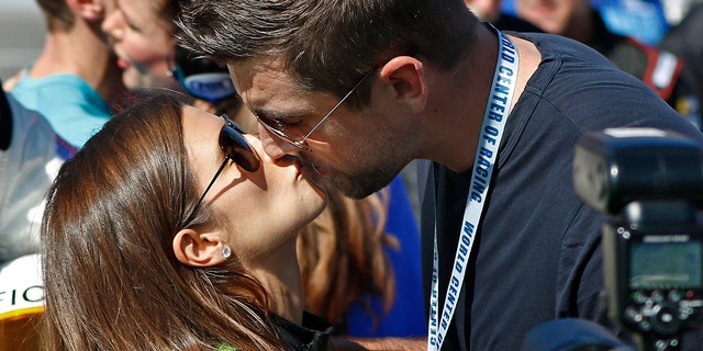 Danica Patrick, links, krijgt een kus van Green Bay Packers quarterback Aaron Rodgers, rechts, voor de NASCAR Daytona 500 Cup series auto race op Daytona International Speedway in Daytona Beach, Fla. Zondag, Februari. 18, 2018.