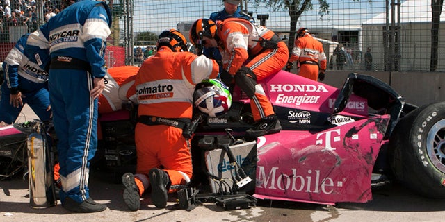 Oct. 6, 2013: Safety team members work to remove Dario Franchitti, of Scotland, from his car after a crash during the second IndyCar Grand Prix of Houston auto race.