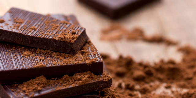 Dark Chocolate with Cocoa on Wooden Table