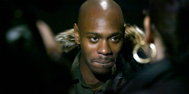 Comedian Dave Chappelle talks to reporters as he arrives for the premiere of his film 'Dave Chappelle's Block Party' in New York February 28, 2006. REUTERS/Keith Bedford - RTR16QS5