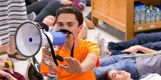 Marjorie Stoneman Douglas High School student David Hogg speaks as demonstrators lie on the floor at a Publix Supermarket in Coral Springs, Fla., May 25, 2018.
