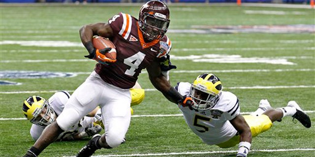Jan. 3, 2012: Virginia Tech running back David Wilson (4) tries to turn the corner past Michigan cornerback Courtney Avery (5) and safety Jordan Kovacs during the first quarter of the Sugar Bowl NCAA college football game in New Orleans.