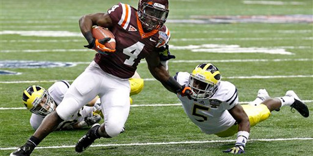 Jan. 3, 2012: Virginia Tech running back David Wilson (4) tries to turn the corner past Michigan cornerback Courtney Avery (5) and safety Jordan Kovacs during the first quarter of the Sugar Bowl NCAA college football game in New Orleans.