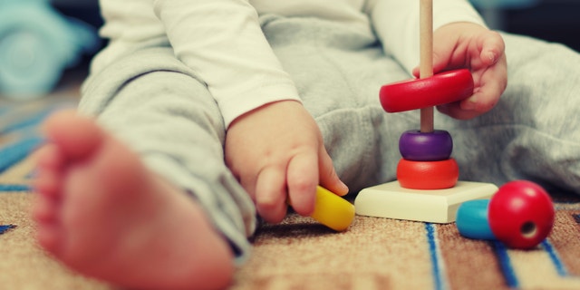 A baby plays with toys.