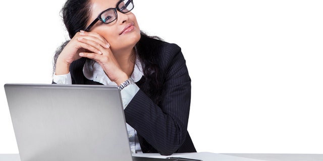 Portait of female entrepreneur working on desk while daydreaming, isolated on white background