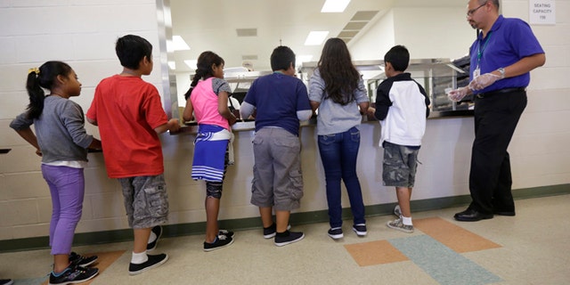 Detained immigrant children line up in the cafeteria at the Karnes County Residential Center, in Karnes City, Texas.
