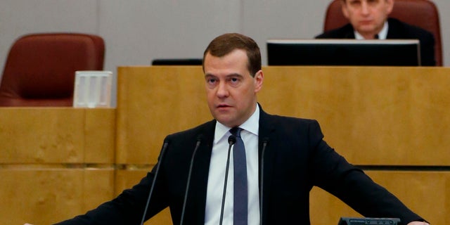 Russian Prime Minister Dmitry Medvedev addresses the State Duma, lower parliament chamber, during an annual report in Moscow on Wednesday, April 17, 2013. Parliament speaker Sergei Naryshkin listens at the background.(AP Photo/RIA Novosti, Dmitry Astakhov, Government Press Service)