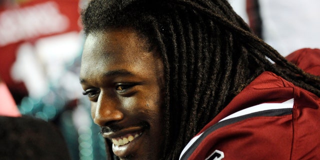 FILE - In this Saturday, Oct. 5, 2013, file photo, South Carolina defensive end Jadeveon Clowney smiles as he sits on the bench during the first half of an NCAA college football game against Kentucky in Columbia, S.C. South Carolina coach Steve Spurrier has said Clowney's availability for Arkansas is up in the air after the All-American defensive end decided not to play in last week's game because of what has been diagnosed as a strained muscle. (AP Photo/Rainier Ehrhardt, File)