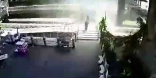 FILE - In this Tuesday, Aug. 18, 2015, photo, people run from an explosion at a ferry pier in Bangkok, Thailand. No one was hurt in Tuesday's blast, but police say the explosive device was thrown from a bridge and blew up after falling into the river below. A Thai court on Thursday, Aug. 27, 2015, issued an arrest warrant for an unnamed suspect in the riverside blast. (Photo via AP)