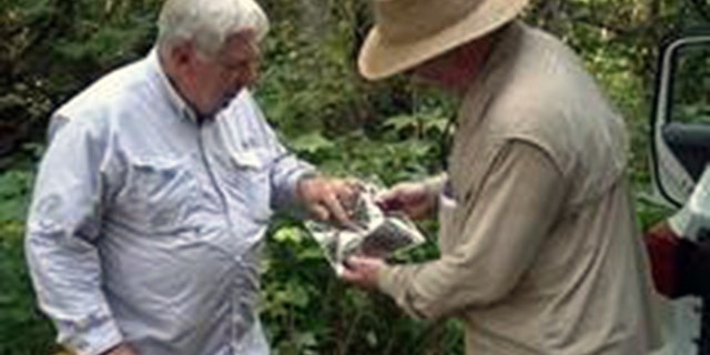 Thomas Colbert, right, is handed the 'potential evidence' by a retired FBI supervisor