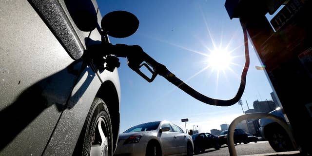 FILE - In this Friday, Jan. 23, 2015, file photo, vehicles form a line behind a motorist gassing up at a gas station in Newark, N.J. The Commerce Department releases its February report on consumer spending, which accounts for 70 percent of economic activity, on Monday, March 30, 2015. (AP Photo/Julio Cortez, File)