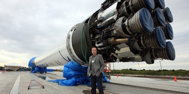 SpaceX Founder, Elon Musk, stands in front of his newest toy -- the Falcon 9 rocket.