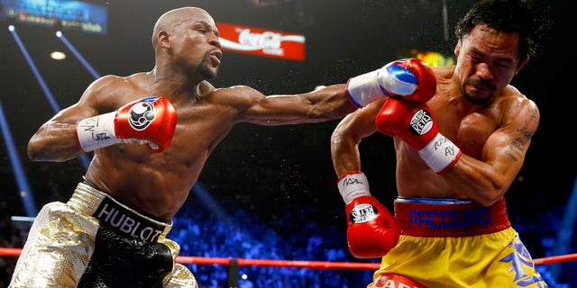 LAS VEGAS, NV - MAY 02: Floyd Mayweather Jr. throws a left at Manny Pacquiao during their welterweight unification championship bout on May 2, 2015 at MGM Grand Garden Arena in Las Vegas, Nevada. (Photo by Al Bello/Getty Images)