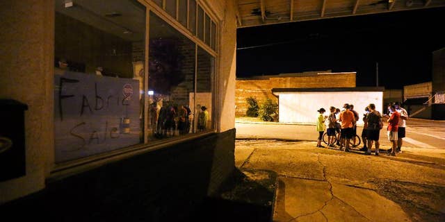 A group of teenagers play "Pokemon Go" in downtown Hartselle, Ala., on Wednesday, July 13, 2016. (Crystal VanderWeit/The Decatur Daily via AP)