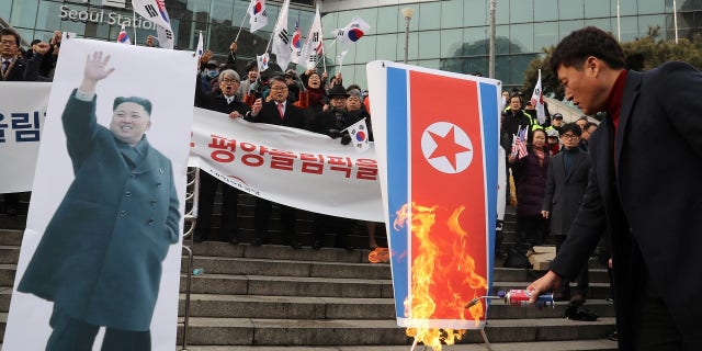 Protesters burn the North Korean flag and photos of Kim Jong Un ahead of the Olympics.