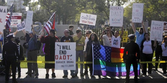 Protesters in favor of repealing the 'Don't Ask, Don't Tell' policy line the motorcade route of President Obama as he passes by in Los Angeles April 19. (Reuters Photo)