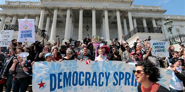 Alejandra Pablos of Arizona, lower right, leads a chant as voting rights reform demonstrators stage a sit-in at the Capitol in Washington, Monday, April 11, 2016, urging lawmakers to take money out of the political process. (AP Photo/J. Scott Applewhite)