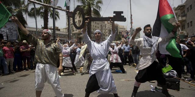 Palestinians act in a play enacting "Nakba" or Catastrophe day in the West Bank city of Ramallah, Sunday, May 15, 2016. Palestinians marked the 68th anniversary of their displacement following the Israeli declaration of independence in 1968. (AP Photo/Majdi Mohammed)