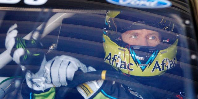 Driver Carl Edwards adjusts his gloves before practice, Friday, May 9, 2014, at Kansas Speedway in Kansas City, Kan., for Saturday night's NASCAR Sprint Cup series auto race. (AP Photo/Colin E. Braley)